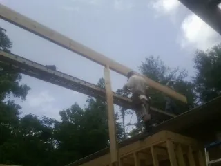 Carpenter setting a ridge beam over a new addition frame — Ice Dam Removal by Roofing Brothers in Richland